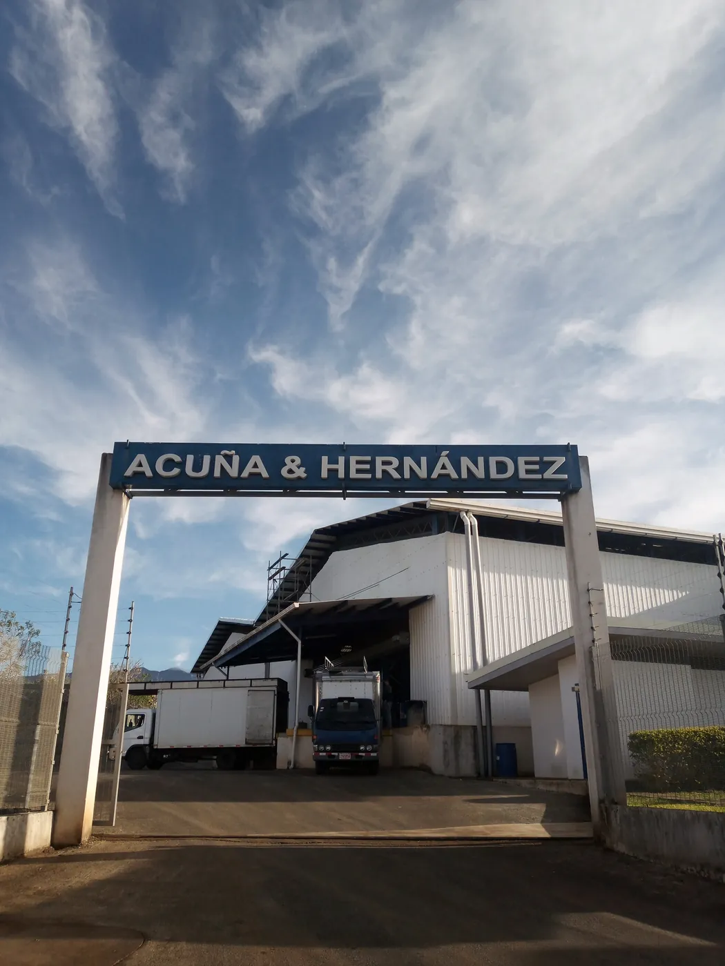 Entrada a la bodega de Acuña & Hernández con camiones de reparto